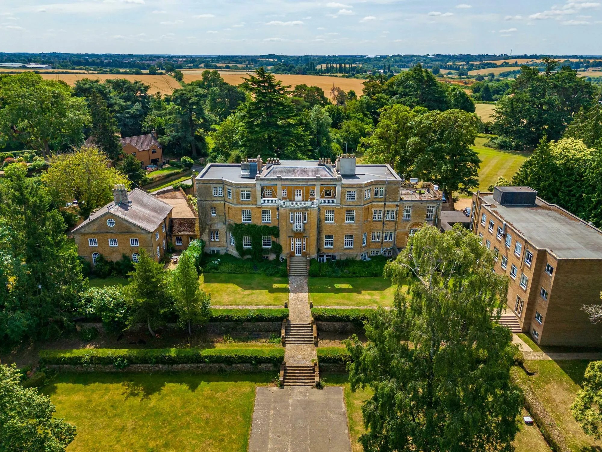 Pitsford Hall and its grounds from the air, open countryside beyond